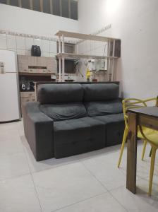 um sofá preto numa sala de estar com uma mesa em Casa Toque toque pequeno em São Sebastião