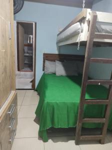 um quarto com um beliche com um lençol verde em Casa Toque toque pequeno em São Sebastião