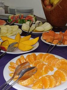 una mesa cubierta con platos de naranjas y otros alimentos en Orquídeas De La Selva en Puerto Iguazú