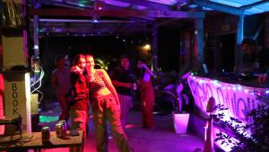 eine Gruppe von Menschen, die in einem Raum mit lila Lichtern tanzen in der Unterkunft The Bear Bungalow in Kampot
