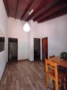 a dining room with a wooden table and a light at Orquídeas De La Selva in Puerto Iguazú