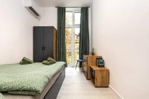 um quarto com uma cama, uma secretária e uma janela em Kapana Beat 2-bedroom apt. Top Center em Plovdiv