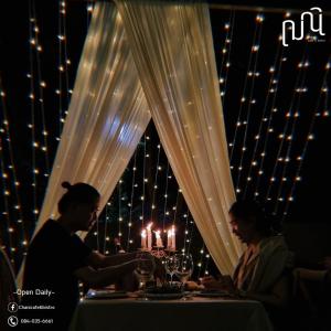 two people sitting at a table with wine glasses at Punn Hotel Korat in Nakhon Ratchasima