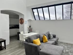 uma sala de estar com um sofá cinzento e almofadas amarelas em Pass the Keys Stylish Unique 2 Bed Duplex Apartment with Parking em Saint Albans