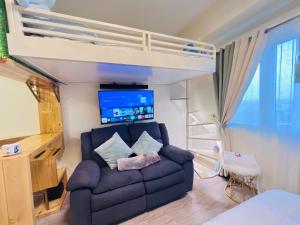 a living room with a couch and a bunk bed at Comfy studio room in Bacolod