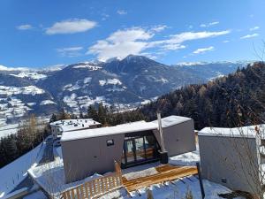 una casa con vista su una montagna innevata di Alptime Tiny Lodge a Fügenberg
