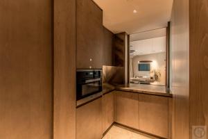 uma cozinha com armários de madeira e um fogão em Super Spacious 3BR with Maid's Room in Five Palm em Dubai