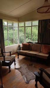 sala de estar con sofá y algunas ventanas en Kudu Haven, en Middelburg