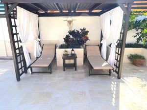 un patio avec deux bancs et une table dans l'établissement Aruba Lagunita, à Palm-Eagle Beach