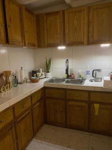 a kitchen with wooden cabinets and a sink at Travelers Oasis in Portmore