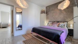 Schlafzimmer mit einem Bett mit lila Bettwäsche und einem Spiegel in der Unterkunft Arte no5 in Novigrad Istria