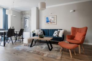 a living room with a blue couch and chairs at 8th Hill Apartments in Plovdiv