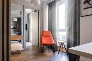 a living room with an orange chair and a table at 8th Hill in Plovdiv