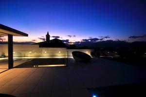 - une vue nocturne sur un bâtiment doté d'une tour d'horloge dans l'établissement Olivera Casa de lujo para 8 piscina en la terraza, à Búger