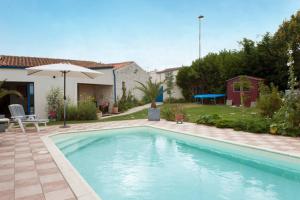 una piscina en un patio con sombrilla en Belle et Grande demeure prés de La Rochelle, en Sainte-Soulle