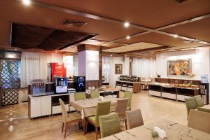 a restaurant with tables and chairs and a buffet at Green Wood Hotel & Spa in Bansko