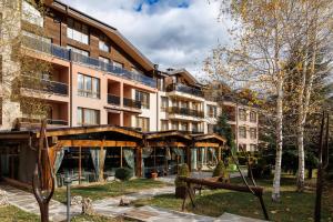 ein Apartmenthaus mit einem Spielplatz davor in der Unterkunft Green Wood Hotel & Spa Bansko in Bansko