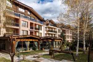 an apartment building with a playground in front of it at Green Wood Hotel & Spa Bansko in Bansko