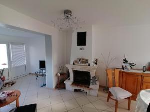 a living room with a fireplace and a chandelier at PAVILLON PROCHE RER et DisneyLand in Gagny