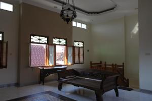 a living room with a bench and windows at Griya Hanna in Yogyakarta