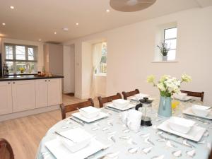a dining room with a table and a kitchen at 4 Bed in Corfe Castle 62985 in Worth Matravers