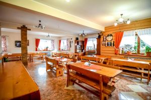 a dining room with wooden tables and windows at Cudzichówka in Biały Dunajec