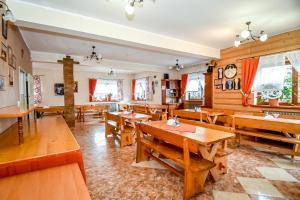 an empty restaurant with wooden tables and benches at Cudzichówka in Biały Dunajec
