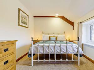 a bedroom with a metal bed in a room at 3 Bed in Umberleigh 65851 in Atherington