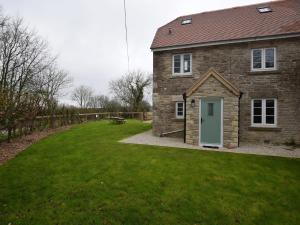 a brick house with a green door in a yard at 4 Bed in Corfe Castle 62985 in Worth Matravers