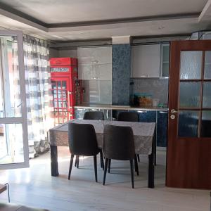 uma cozinha com mesa e cadeiras e uma cabina telefónica vermelha em Апартамент МИА em Plovdiv