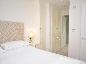 Dormitorio blanco con cama blanca y puerta de entrada en 2 Bed in Okehampton 74242 en Okehampton