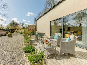 un patio con sillas, mesas y plantas en 1 Bed in Great Torrington 76790 en Shebbear