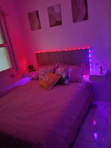 Un dormitorio con una cama con luces moradas. en BLACK *mês* Apartamento na capital Gaúcha, en Porto Alegre