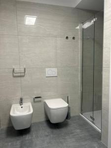 uma casa de banho com um WC, um lavatório e um chuveiro em LabPark Relax Apartment em Melano