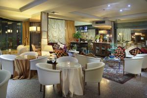a restaurant with tables and chairs and a lobby at Hotel Nuovo Savi in Montecatini Terme