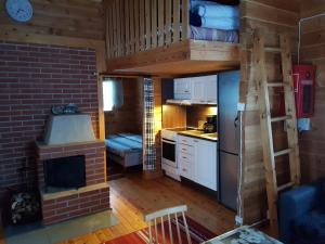 Habitación con cama elevada y cocina con chimenea. en Villa Mäkivaski, en Virrat