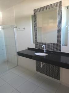 a bathroom with a sink and a mirror and a shower at Casalagoana in Marechal Deodoro
