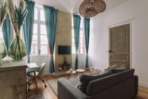uma sala de estar com um sofá e uma televisão em By Homy em Bordeaux