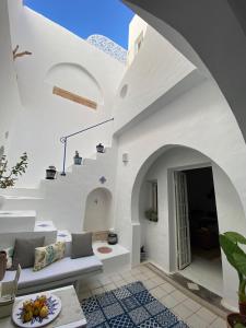 a living room with white walls and a white couch at Dar AZUR HAMMAMET FORT in Hammamet