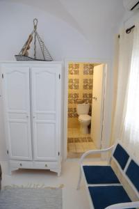 Dar AZUR HAMMAMET FORT في الحمامات: حمام مع خزانة بيضاء ومرحاض