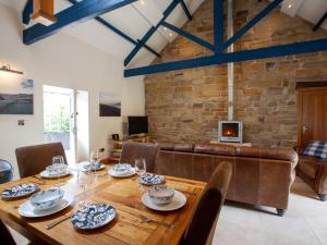 a dining room with a wooden table and a couch at 2 bed in Osmotherley G0108 in Chop Gate