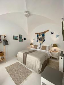 a white bedroom with a bed and a rug at Dar AZUR HAMMAMET FORT in Hammamet