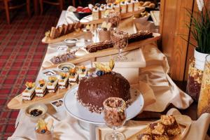 a table topped with a chocolate cake and other desserts at Pirin Golf & Country Club Apartment Complex in Bansko