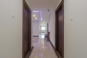 un pasillo con dos puertas y un pasillo con una silla en Townhouse Hotel Dj Grand en Tirupati