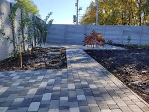 einen Garten mit einem gemauerten Gehweg vor einem Zaun in der Unterkunft house for relaxation in Kriukivshchyna