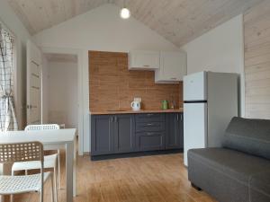 a kitchen with a table and a white refrigerator at house for relaxation in Kriukivshchyna