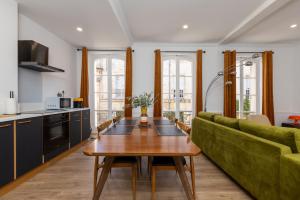 a living room with a green couch and a table at Le Vernet in Avignon