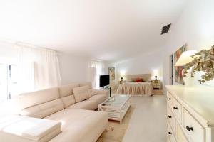 sala de estar blanca con sofá y cama en Alojamiento Rural Finca Barral en Sevilla