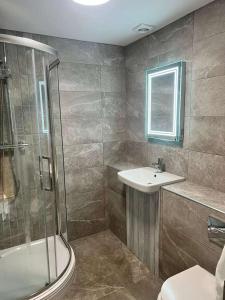 a bathroom with a shower and a sink and a toilet at The Dunes Hotel in Barrow in Furness