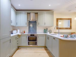 una cocina con armarios blancos y fregadero en 2 Bed in Westward Ho 77590, en Northam